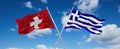 two crossed flags Greece and Switzerland waving in wind at cloudy sky. Concept of relationship, dialog, travelling between two