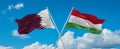 two crossed flags Hungary and Qatar waving in wind at cloudy sky. Concept of relationship, dialog, travelling between two