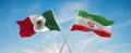 two crossed flags Iran and mexico waving in wind at cloudy sky. Concept of relationship, dialog, travelling between two countries