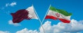 two crossed flags Iran and Qatar waving in wind at cloudy sky. Concept of relationship, dialog, travelling between two countries