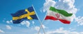 two crossed flags Iran and Sweden waving in wind at cloudy sky. Concept of relationship, dialog, travelling between two countries