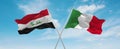 two crossed flags Italy and Iraq waving in wind at cloudy sky. Concept of relationship, dialog, travelling between two countries