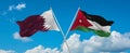 two crossed flags Jordan and Qatar waving in wind at cloudy sky. Concept of relationship, dialog, travelling between two countries