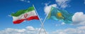 two crossed flags Kazakhstan and Iran waving in wind at cloudy sky. Concept of relationship, dialog, travelling between two