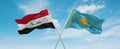 two crossed flags Kazakhstan and Iraq waving in wind at cloudy sky. Concept of relationship, dialog, travelling between two