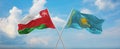 two crossed flags Kazakhstan and Oman waving in wind at cloudy sky. Concept of relationship, dialog, travelling between two