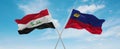 two crossed flags Liechtenstein and Iraq waving in wind at cloudy sky. Concept of relationship, dialog, travelling between two