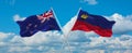 two crossed flags Liechtenstein and New Zealand waving in wind at cloudy sky. Concept of relationship, dialog, travelling between