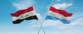 two crossed flags Luxembourg and Iraq waving in wind at cloudy sky. Concept of relationship, dialog, travelling between two