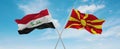 two crossed flags Macedonia and Iraq waving in wind at cloudy sky. Concept of relationship, dialog, travelling between two