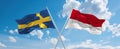 two crossed flags Monaco and Sweden waving in wind at cloudy sky. Concept of relationship, dialog, travelling between two