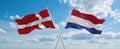 two crossed flags netherlands and Denmark waving in wind at cloudy sky. Concept of relationship, dialog, travelling between two