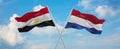 two crossed flags netherlands and Egypt waving in wind at cloudy sky. Concept of relationship, dialog, travelling between two