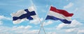 two crossed flags netherlands and finland waving in wind at cloudy sky. Concept of relationship, dialog, travelling between two
