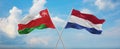 two crossed flags netherlands and Oman waving in wind at cloudy sky. Concept of relationship, dialog, travelling between two