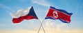 two crossed flags North Korea and Czech republic waving in wind at cloudy sky. Concept of relationship, dialog, travelling