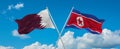 two crossed flags North Korea and Qatar waving in wind at cloudy sky. Concept of relationship, dialog, travelling between two