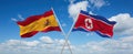 two crossed flags North Korea and spain waving in wind at cloudy sky. Concept of relationship, dialog, travelling between two