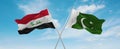 two crossed flags Pakistan and Iraq waving in wind at cloudy sky. Concept of relationship, dialog, travelling between two