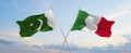 two crossed flags Pakistan and Italy waving in wind at cloudy sky. Concept of relationship, dialog, travelling between two