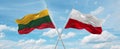 two crossed flags poland and Lithuania waving in wind at cloudy sky. Concept of relationship, dialog, travelling between two