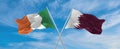 two crossed flags Qatar and Ireland waving in wind at cloudy sky. Concept of relationship, dialog, travelling between two