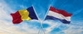 two crossed flags romania and Netherland waving in wind at cloudy sky. Concept of relationship, dialog, travelling between two