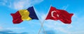 two crossed flags romania and Turkey waving in wind at cloudy sky. Concept of relationship, dialog, travelling between two