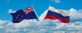 two crossed flags Russia and New Zealand waving in wind at cloudy sky. Concept of relationship, dialog, travelling between two