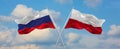 two crossed flags Russia and Poland waving in wind at cloudy sky. Concept of relationship, dialog, travelling between two Royalty Free Stock Photo