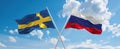 two crossed flags Russia and Sweden waving in wind at cloudy sky. Concept of relationship, dialog, travelling between two