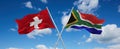 two crossed flags South Africa and Switzerland waving in wind at cloudy sky. Concept of relationship, dialog, travelling between