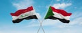 two crossed flags Sudan and Iraq waving in wind at cloudy sky. Concept of relationship, dialog, travelling between two countries