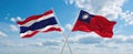 two crossed flags Taiwan and Thailand waving in wind at cloudy sky. Concept of relationship, dialog, travelling between two
