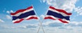 two crossed flags thailand and Thailand waving in wind at cloudy sky. Concept of relationship, dialog, travelling between two