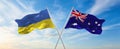two crossed flags Ukraine and Australia waving in wind at cloudy sky. Concept of relationship, dialog, travelling between two