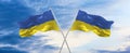 two crossed flags Ukraine and Ukraine waving in wind at cloudy sky. Concept of relationship, dialog, travelling between two