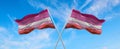 two crossed Lesbian Pride flags waving in the wind on flagpole against the sky with clouds on sunny day. 3d illustration Royalty Free Stock Photo