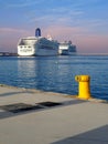 Two cruise ships docked at the port face to face on a day with blue sky with a yellow bollard Royalty Free Stock Photo