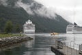 Two cruise ships are moored in a fjord in Norway and are waiting for passengers to disembark with dinghies