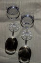 Two crystal glasses with drinks. Glare from the light. The shadows. Reflection on the water. Clear water in a wine glass. An Royalty Free Stock Photo