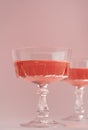 Two crystal glasses of rose sparkling wine or champagne on pastel pink background. Minimal creative composition with Royalty Free Stock Photo