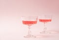 Two crystal glasses of rose sparkling wine or champagne on pastel pink background. Minimal creative composition with Royalty Free Stock Photo