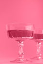 Two crystal glasses of sparkling wine or champagne. Toned image in trendy magenta color of year 2023. Royalty Free Stock Photo