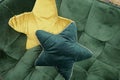 Two cuddly yellow star-shaped pillow on a green sofa Royalty Free Stock Photo