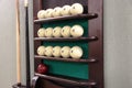 Two cue, lots of white balls and one brown ball on the ball rack to play Russian Billiards