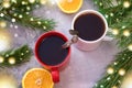 Two cup of coffee or hot chokolate and branches of Christmas tree. Festive background with beautiful Christmas lights of bokeh Royalty Free Stock Photo