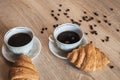 Two cup of hot coffee in a plate and a croissants Royalty Free Stock Photo