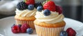 Two Cupcakes With White Frosting and Fresh Berries Royalty Free Stock Photo