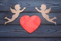 Two cupids and a red heart made of wood texture.